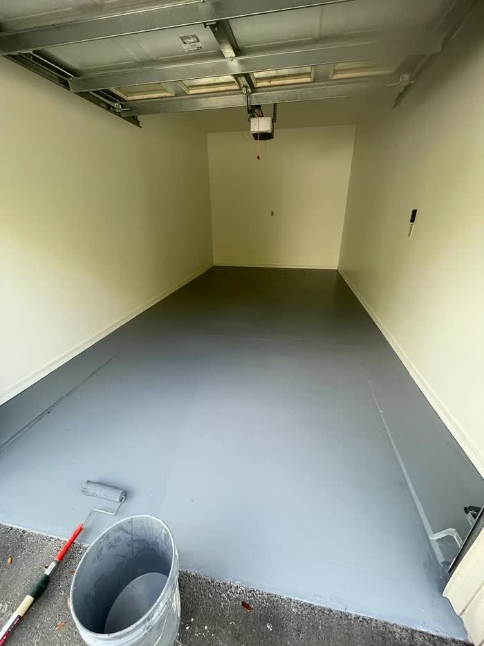The same garage after the work: repainted walls and a grey coated floor.