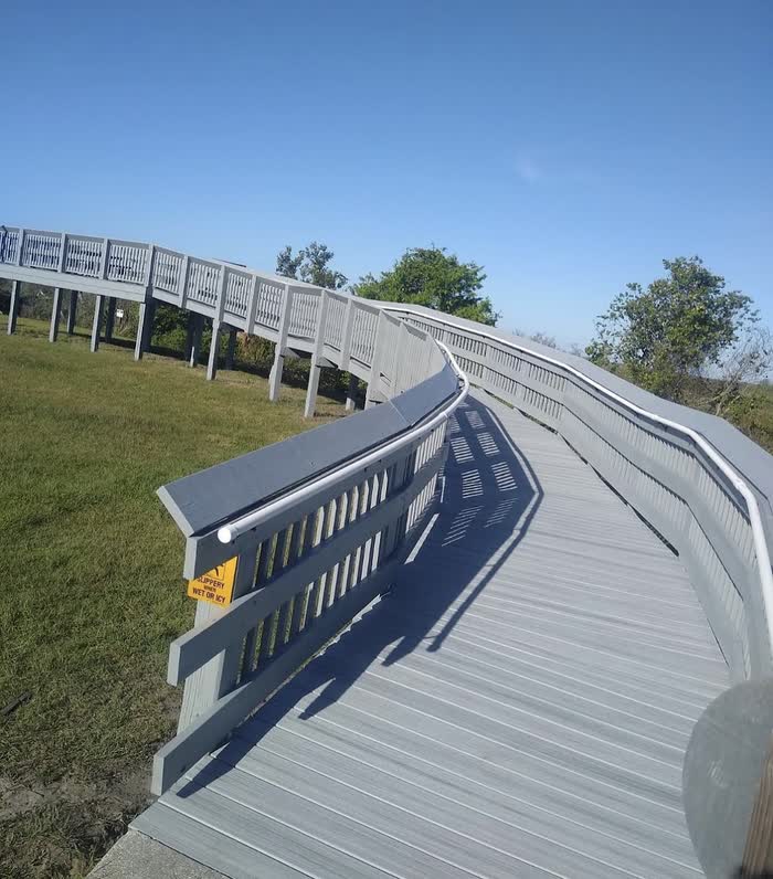 Railings and posts along the raised walkway now painted grey, matching the boards underfoot.