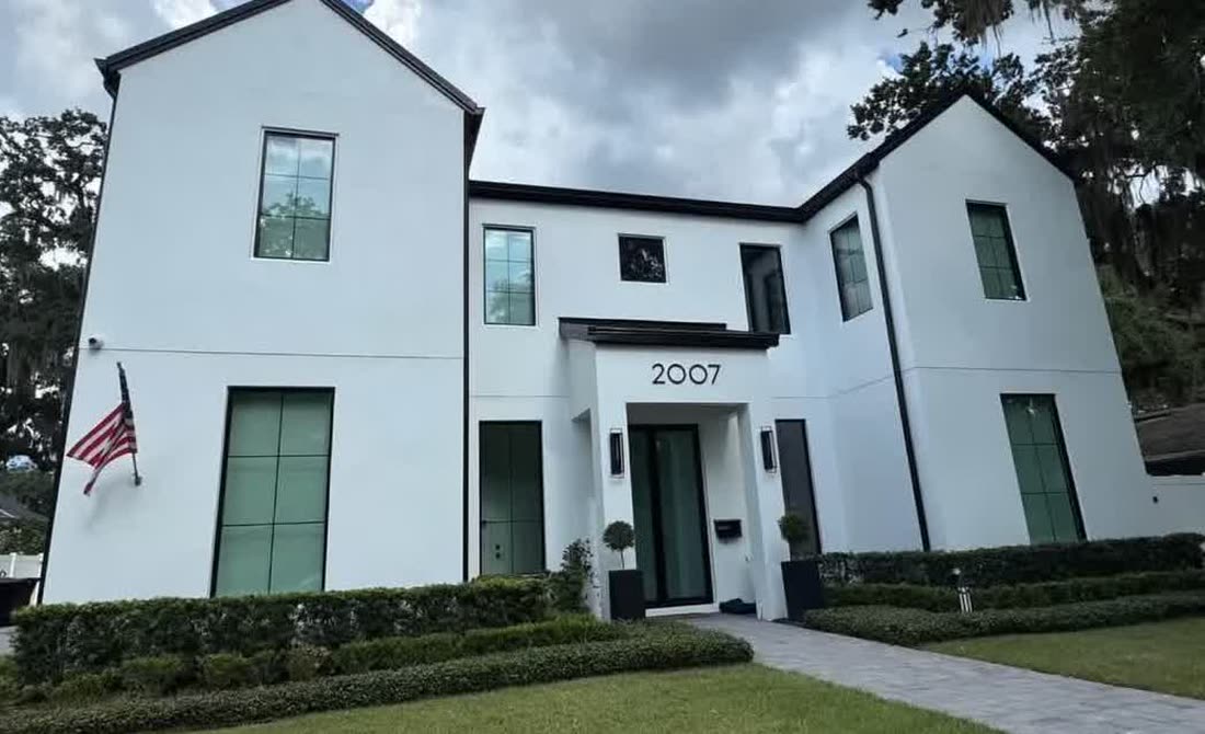 The same house after painting, in white with black trim.